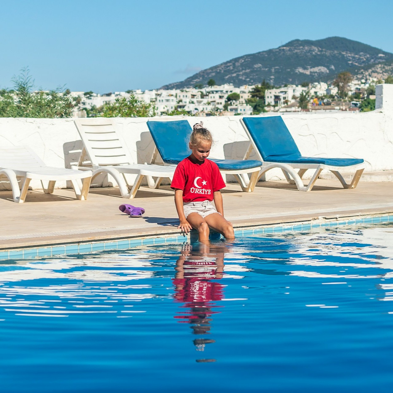 little-girl-is-sitting-on-pool-side